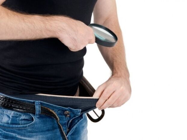 A man looks down his pants and wants to enlarge his penis