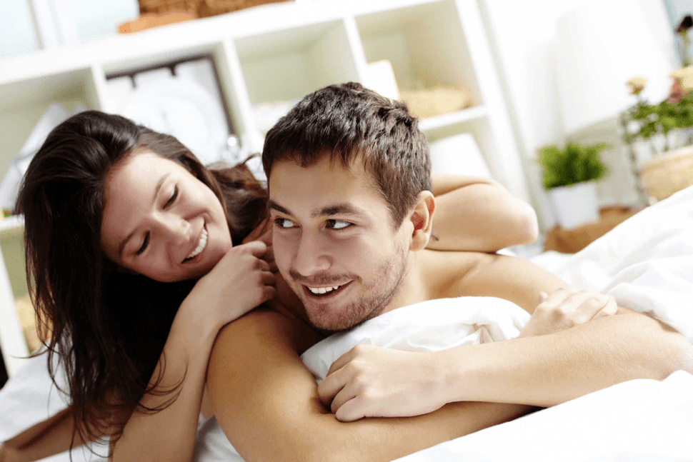 woman in bed with a man raising a dick with a muzzle
